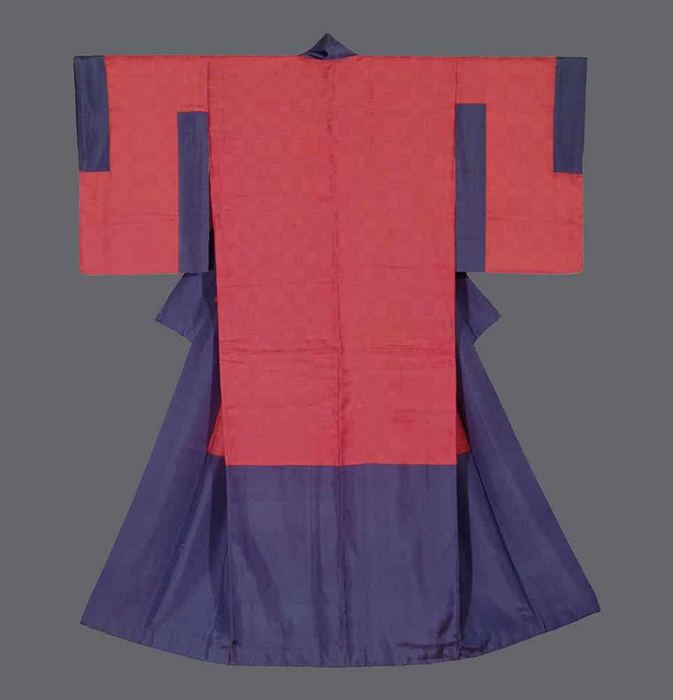 Traditional Japanese red and blue kimono hanging flat against gray background