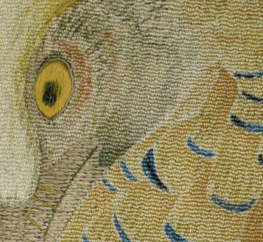 Detailed close-up of woven textile with yellow eye-like shape and blue patterns