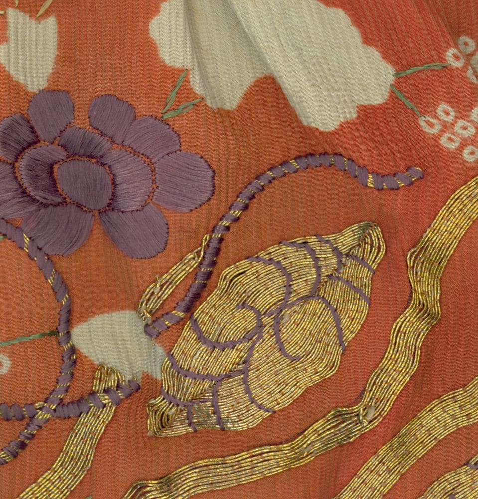 Intricate embroidery with purple flower and gold-threaded snail design