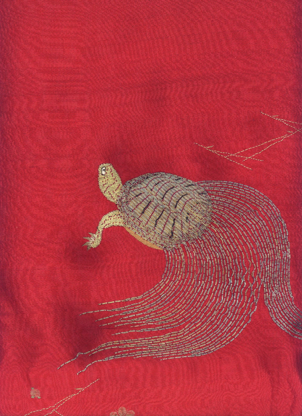 Embroidered turtle with intricate stitching on vibrant red textile background