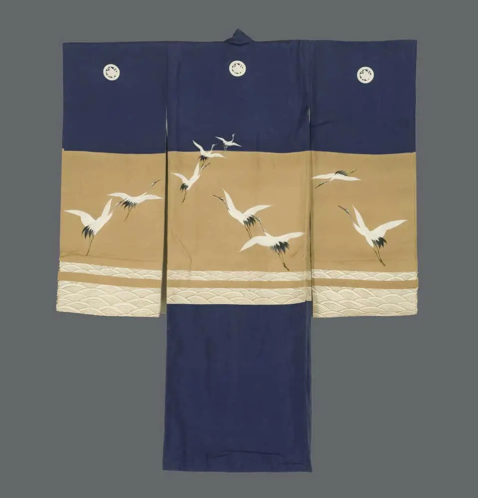 Child’s ceremonial kimono with deep indigo and ochre fields, white wave bands, and yuzen‑painted sumi‑e‑style cranes in flight reflecting nihonga influence