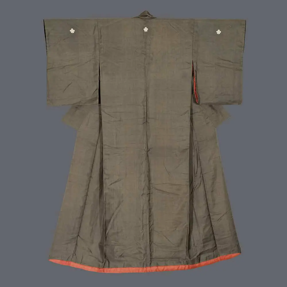Dark olive silk uchikake with subtle woven texture, three white floral crests, a weighted fuki hem, and coral‑vermillion lining glimpses