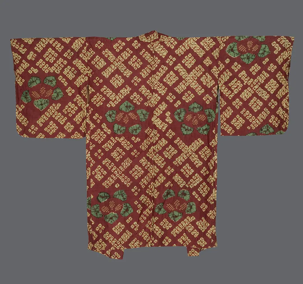 Shibori haori with vibrant green tachibana forms on a burgundy ground, paired with a golden diamond lattice in a balanced chirashi scattered layout 