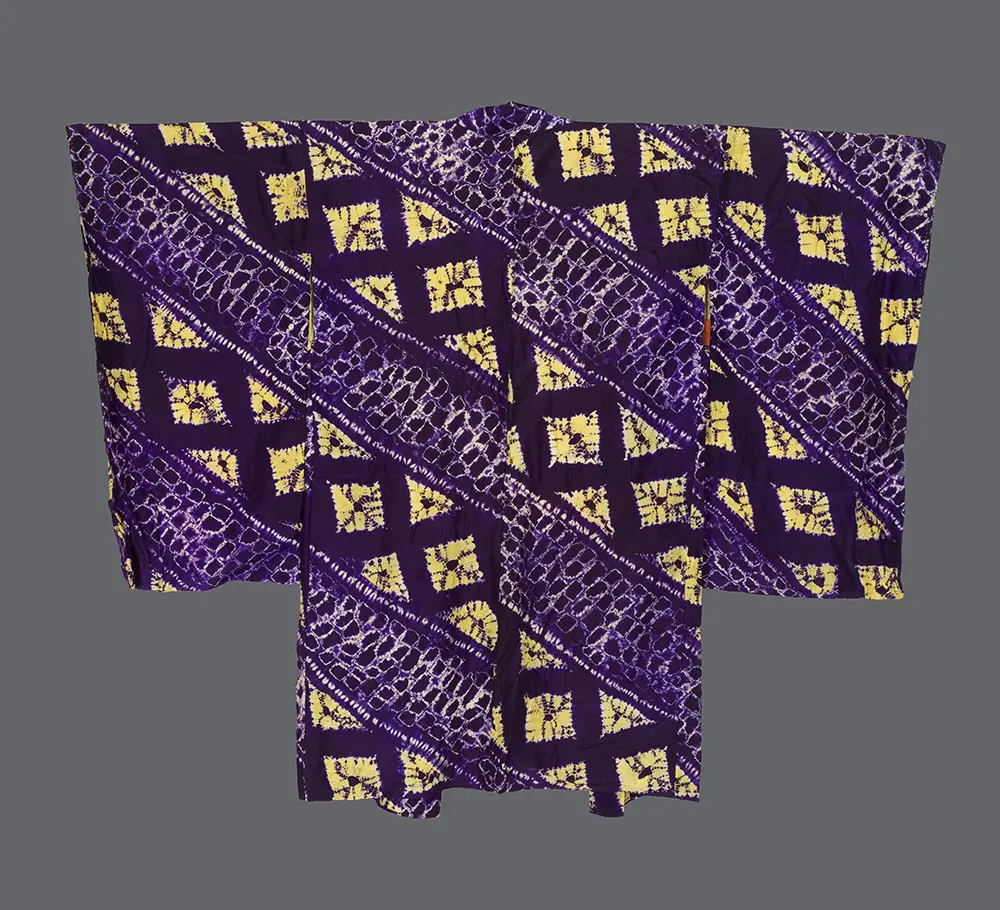 Taishō silk haori with shibori‑dyed diagonal lattice bands forming diamond compartments filled with soft yellow foliate motifs on a rich purple ground 