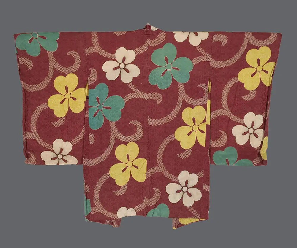 Rinzu silk haori with kata‑yuzen sakura in sage, golden yellow, and cream on a burgundy damask ground, accented by flowing ribbon forms and faux kanoko dots 