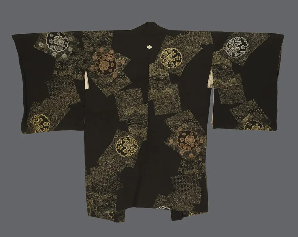 Black silk haori with shimmering urushi‑thread geometric fragments and stylized circular floral medallions, accented with gold, silver, and bronze against a dark ground 