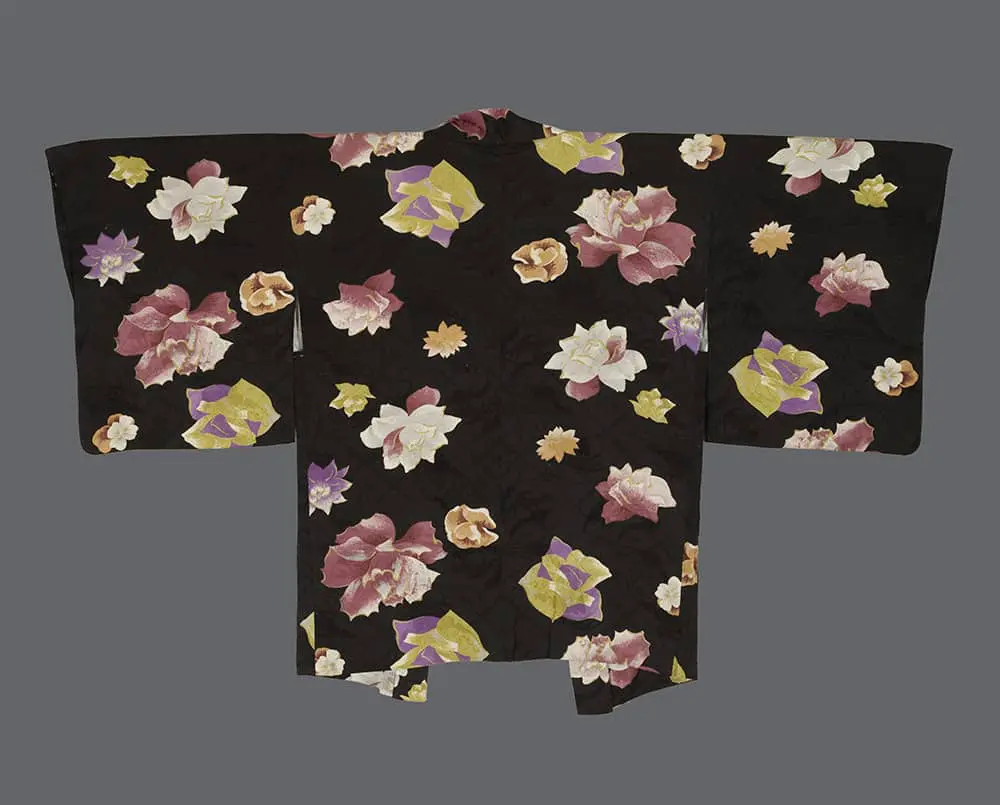 Rinzu silk haori with dusty rose, lavender, golden yellow, and cream blooms scattered across a deep black damask ground in an asymmetrical, dynamic composition 
