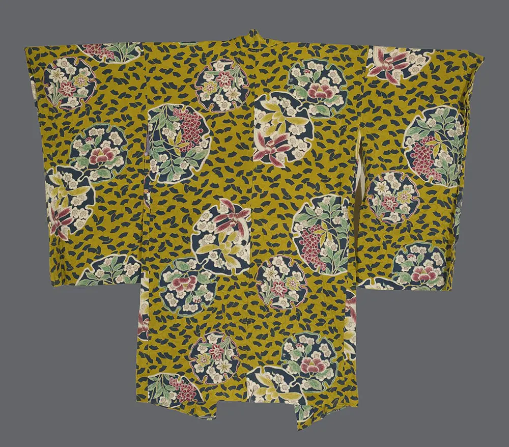 Mustard-yellow rinzu silk haori featuring colorful floral roundel medallions on a dark patterned background.