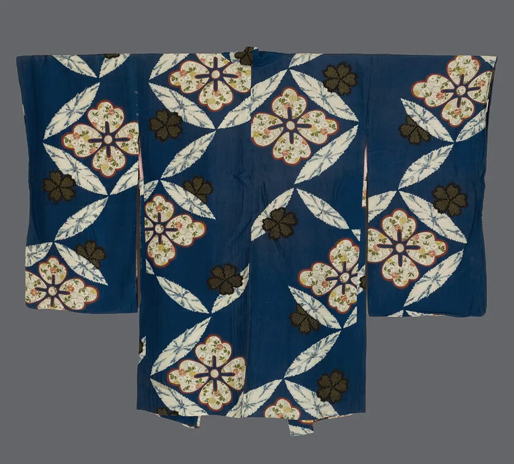 Indigo-blue jiginu silk haori with large white floral medallions containing colorful roses and bronze flower accents.