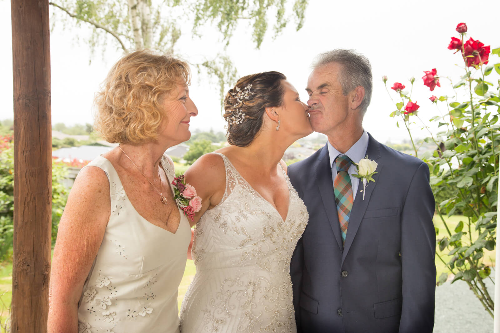 bride and groom kissing during a wedding watched by the bridesmaid