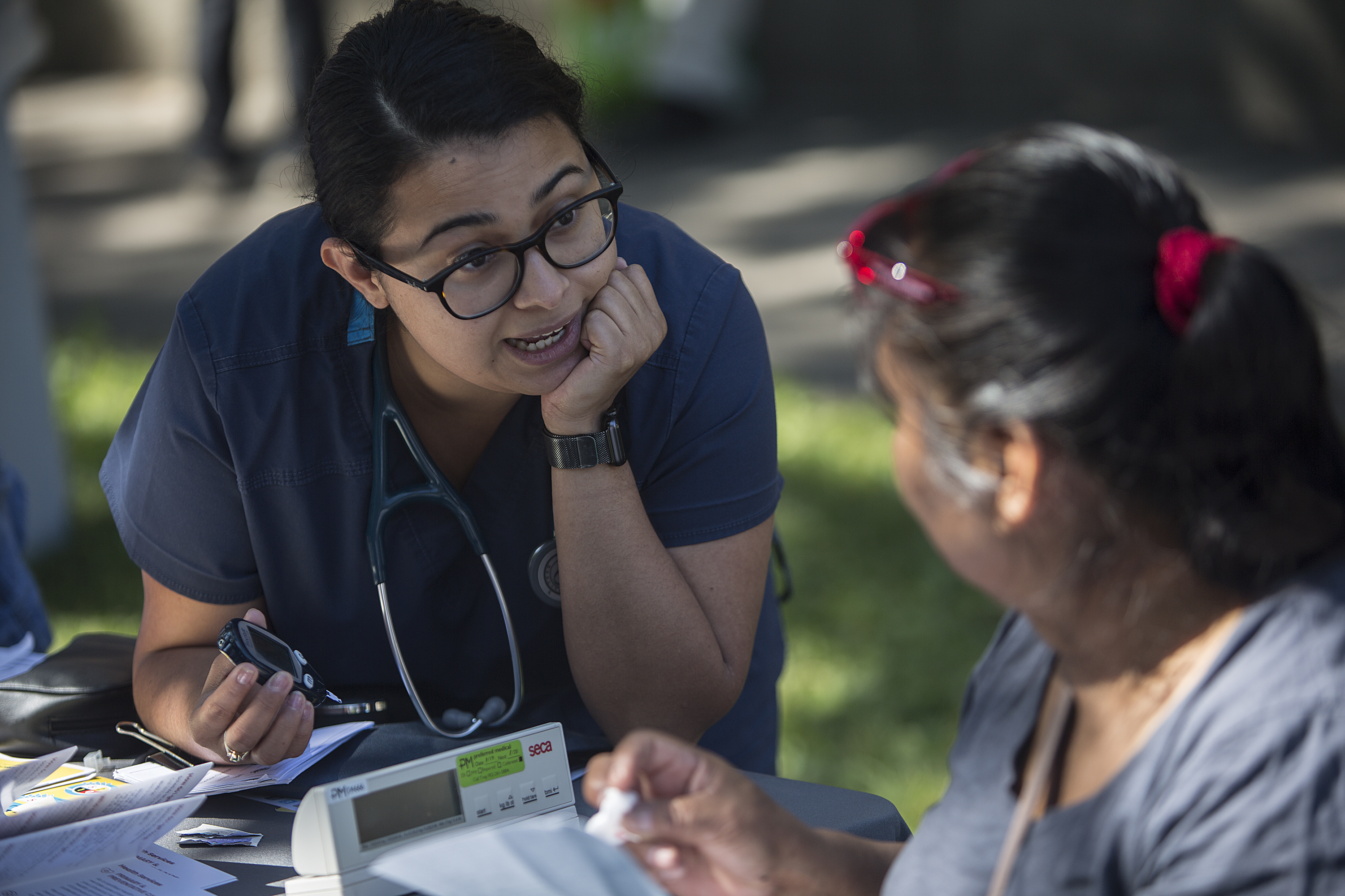Health care professional speaking to a person at an information booth