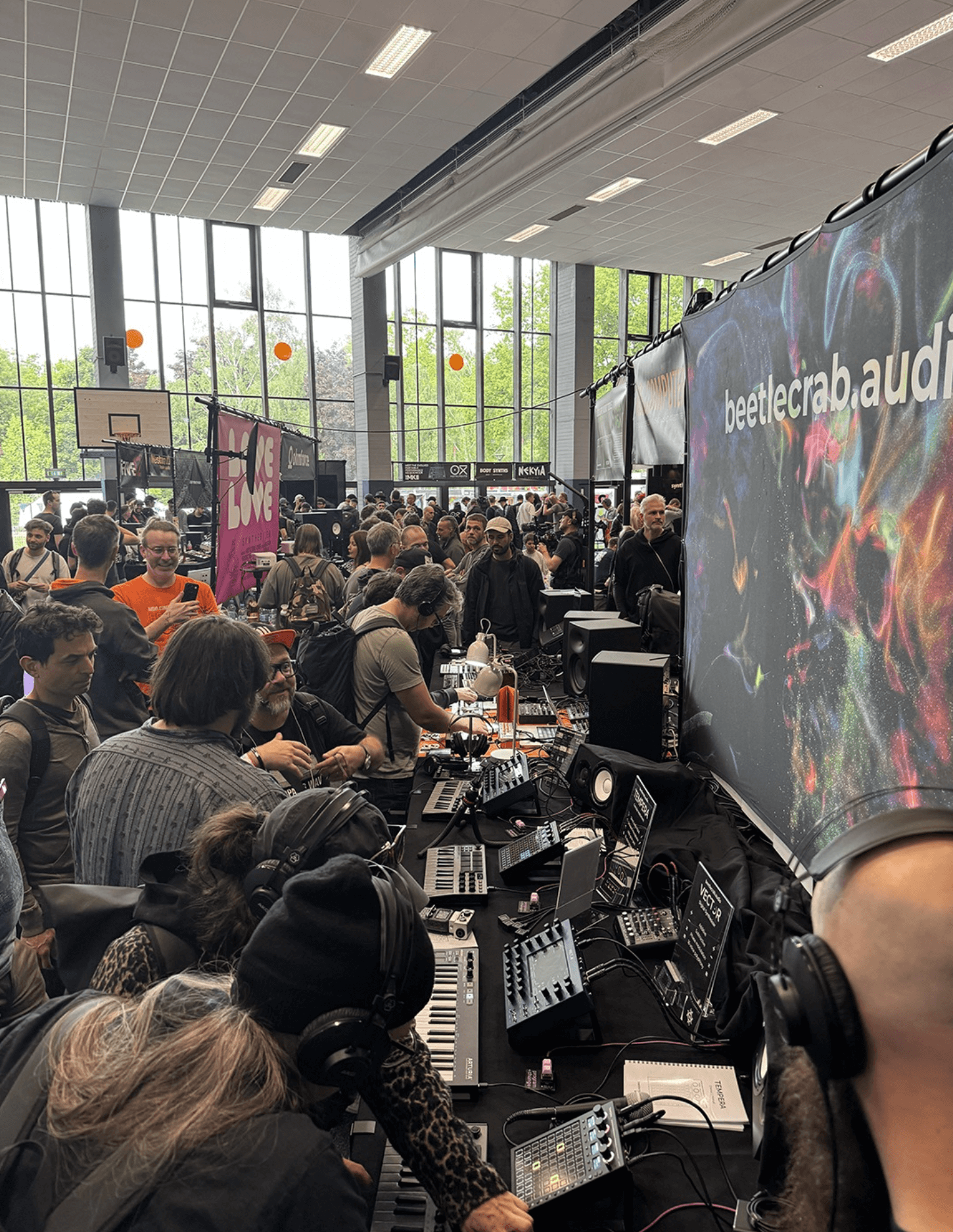 Many people in a room playiing with Synthesizer