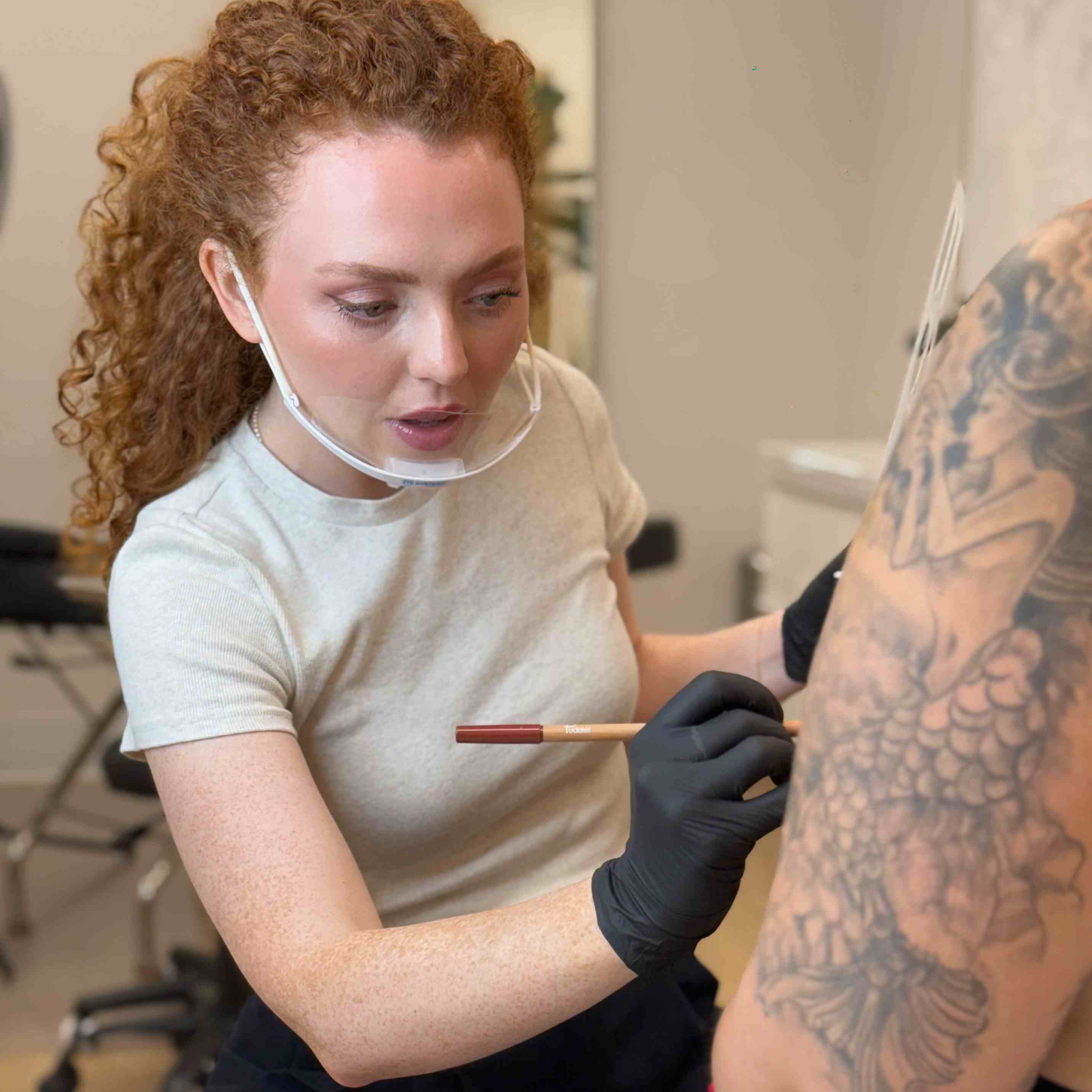 tattoo artist working on areola tattoo