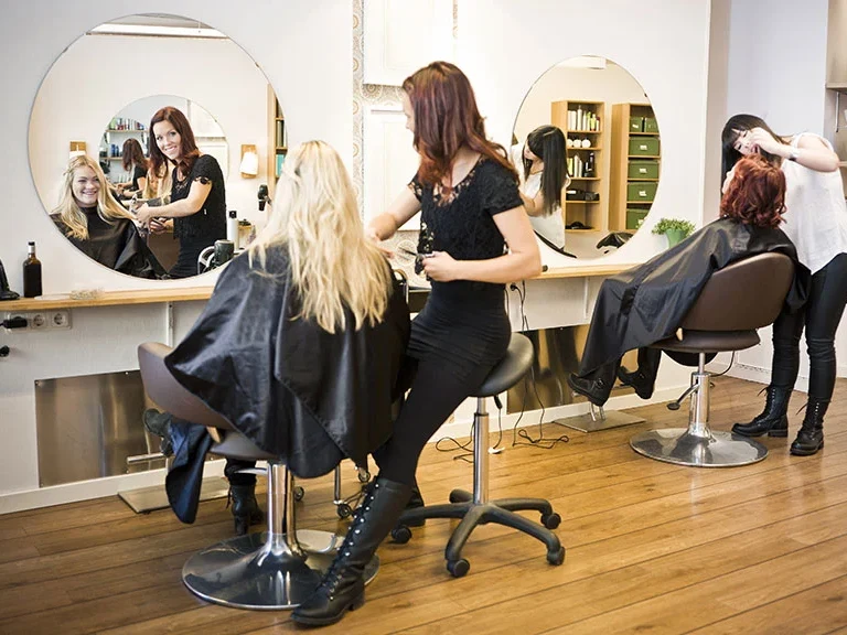 Friseursalon mit mehreren Arbeitsplätzen, Friseurinnen bei der Arbeit