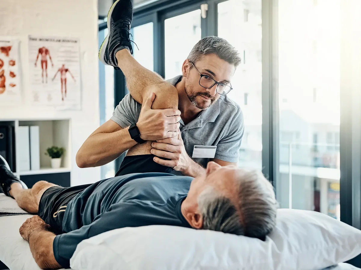 Physiotherapeut behandelt Patienten auf der Liege