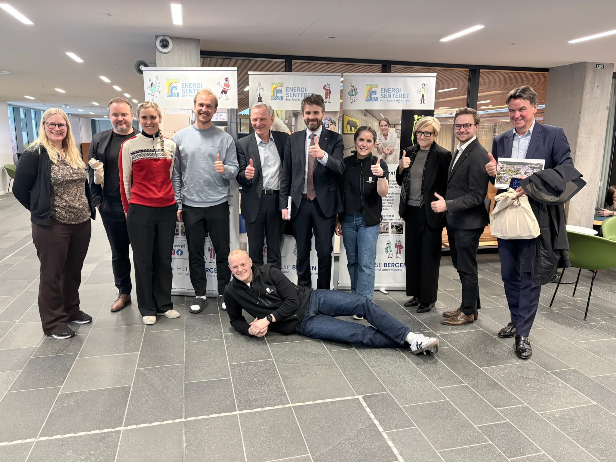 Eit bilde utenfor gymsalen ved Energisenteret for barn og unge, på bilete er det representantar som er med under møtet med Jan Christian Vestre, helseminister.