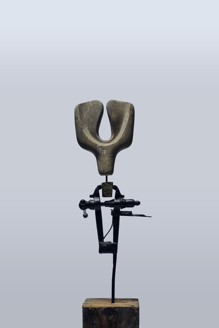 A mixed media abstract sculpture, using metal and stone