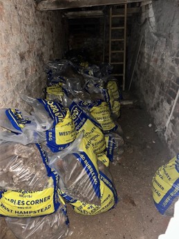 Photograph of sacks filled with the soil and rubble removed from the cellar