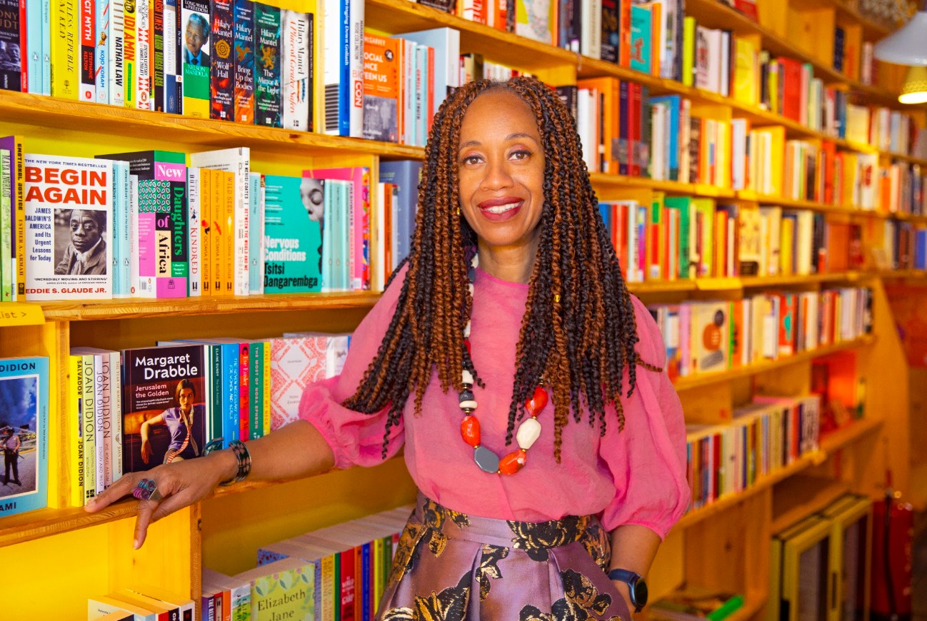 Joy Francis, standing in front of bookshelves