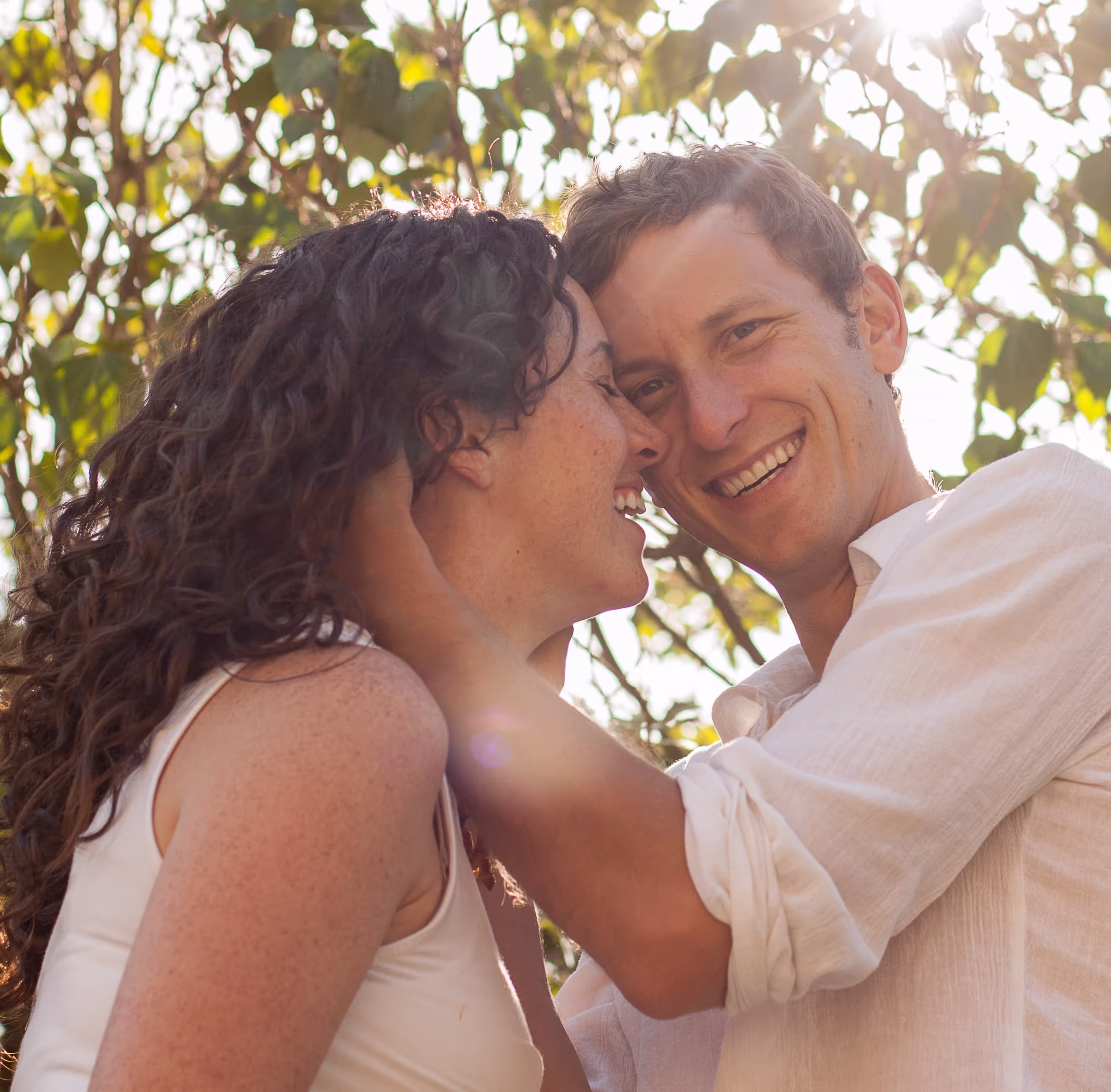 Attractive couple of half black half Caucasian man with his arm around a Caucasian woman with long brown hair smiling