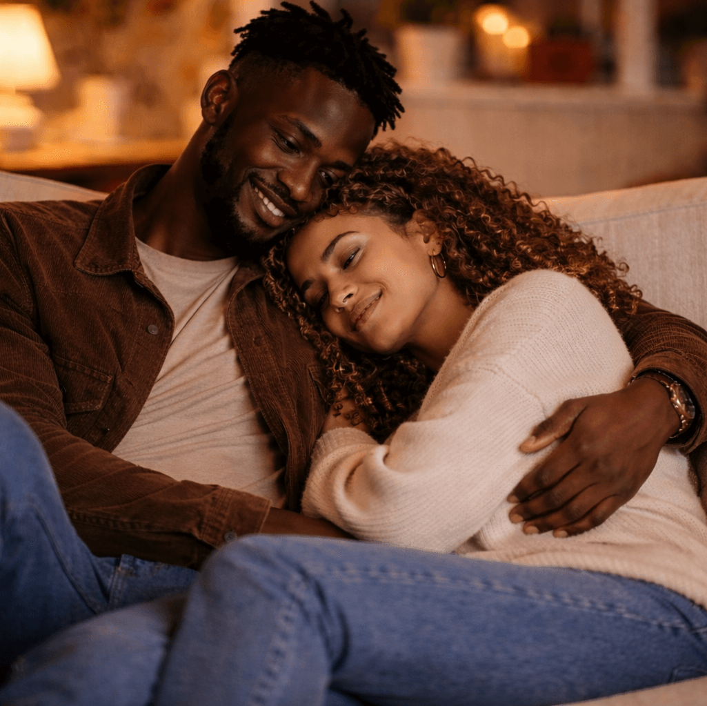 Attractive couple of half black half Caucasian man with his arm around a Caucasian woman with long brown hair smiling