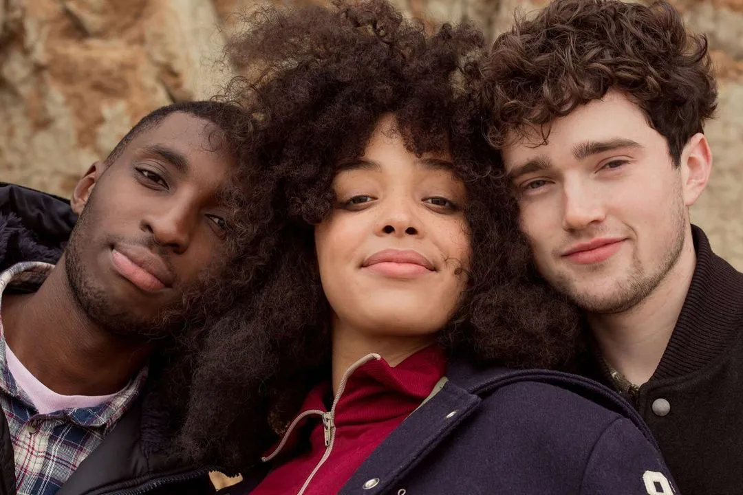 Attractive couple of half black half Caucasian man with his arm around a Caucasian woman with long brown hair smiling