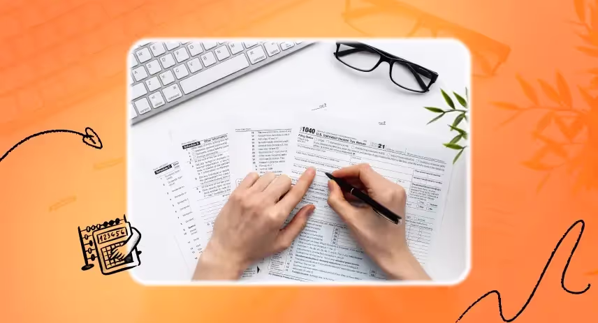 Hands of a person holding a pen and reviewing tax documents.