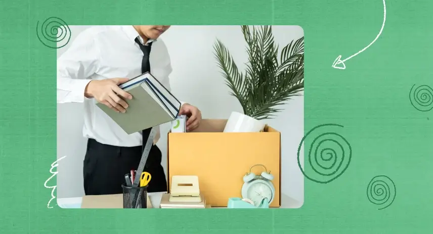 Man packing office items into a cardboard box.
