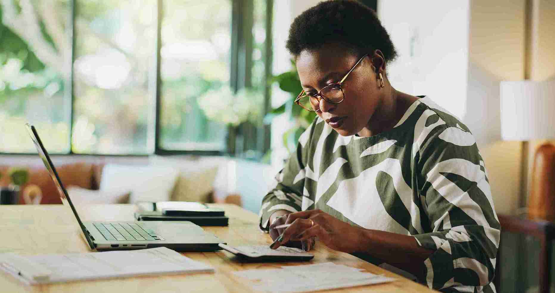 image of a woman using a computer and a calculator