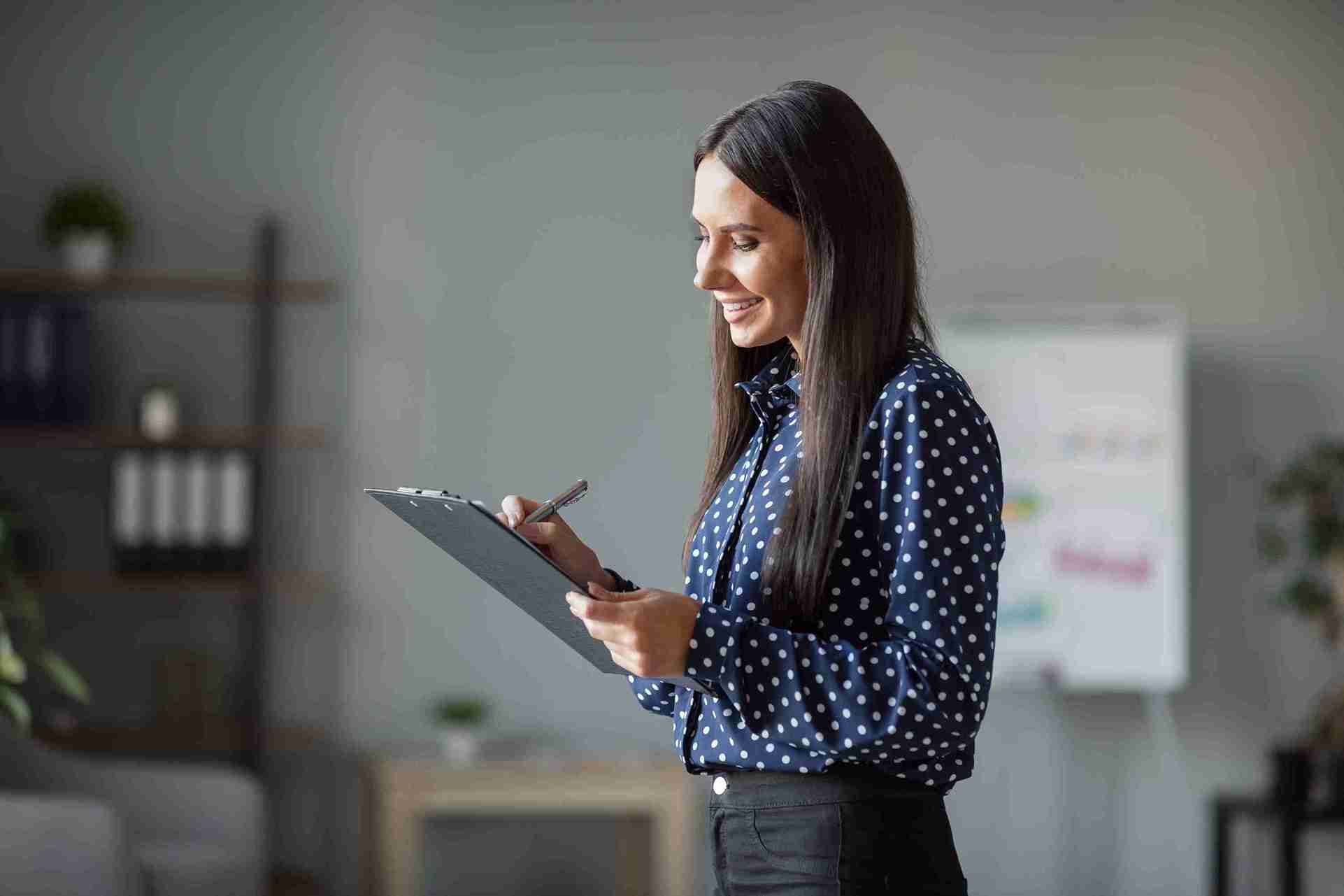 Image of a smiling woman filling out a form.