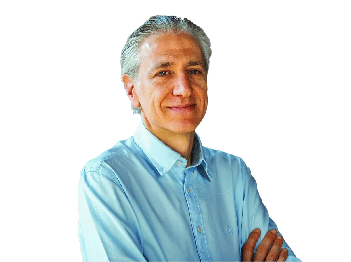 Middle-aged man with silver hair wearing a light blue button-up shirt, standing with arms crossed and a slight smile.