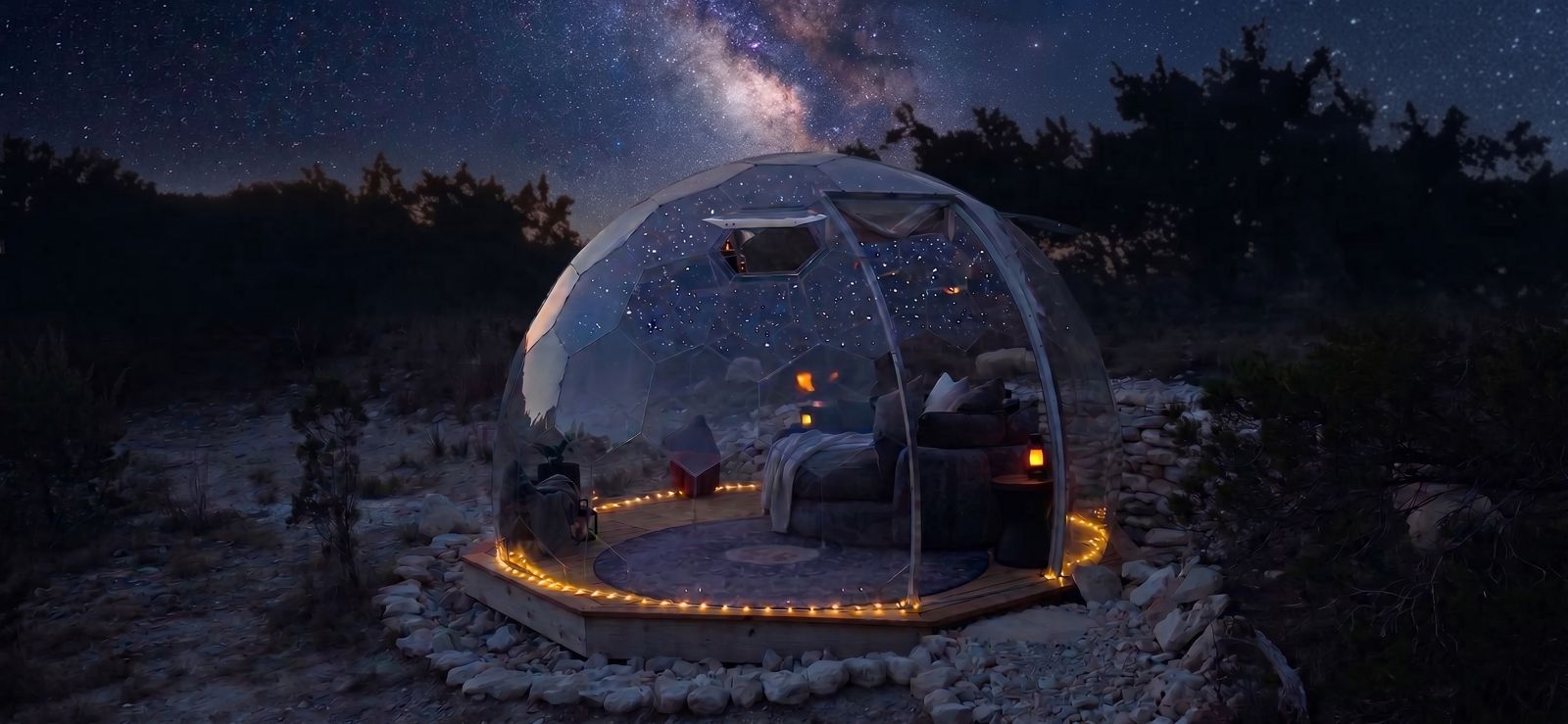 The Hype dome lit from inside on its wooden deck, the Milky Way rising over the cedars