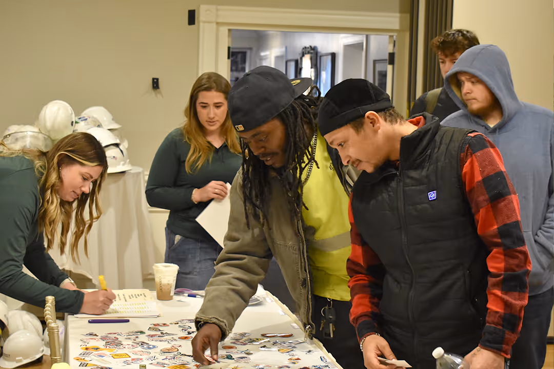 An image of the Trinity Subsurface team looking at construction helmet stickers.