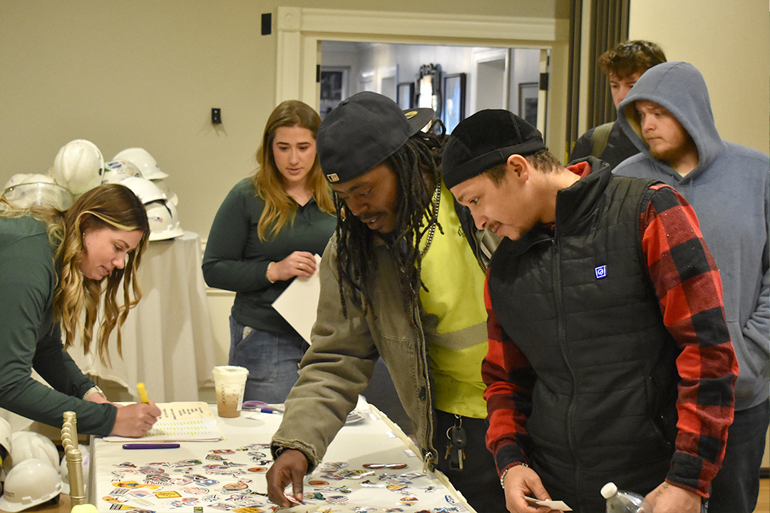 An image of the Trinity Subsurface team looking at construction helmet stickers.
