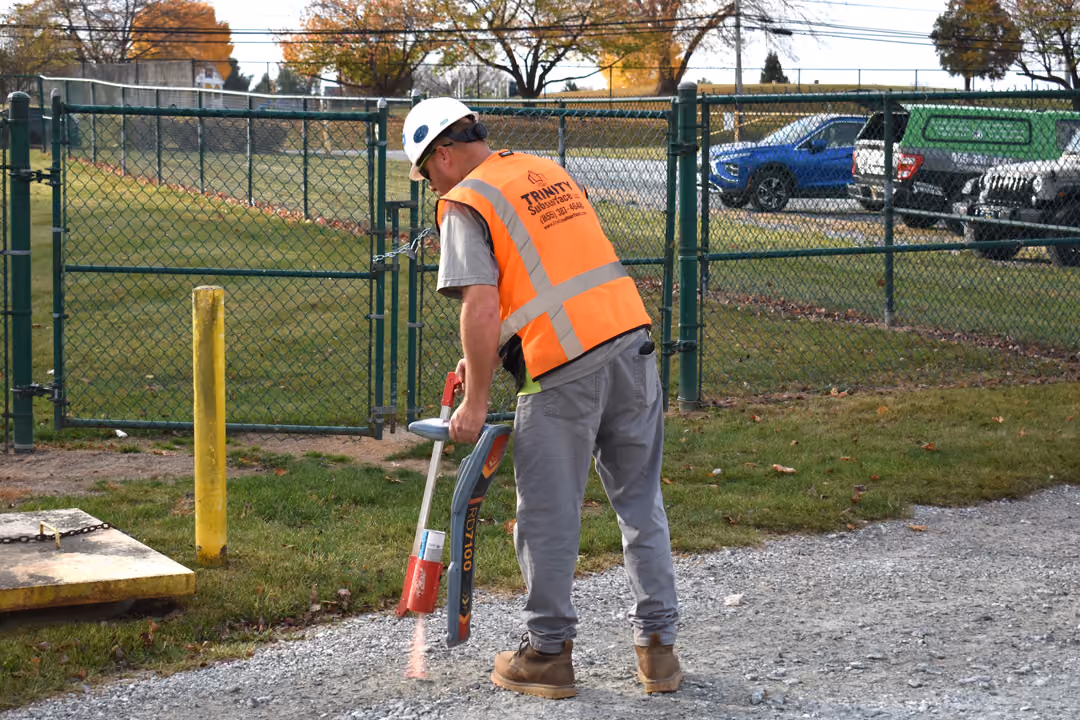 An image of a utility locating technician in a parking lot.