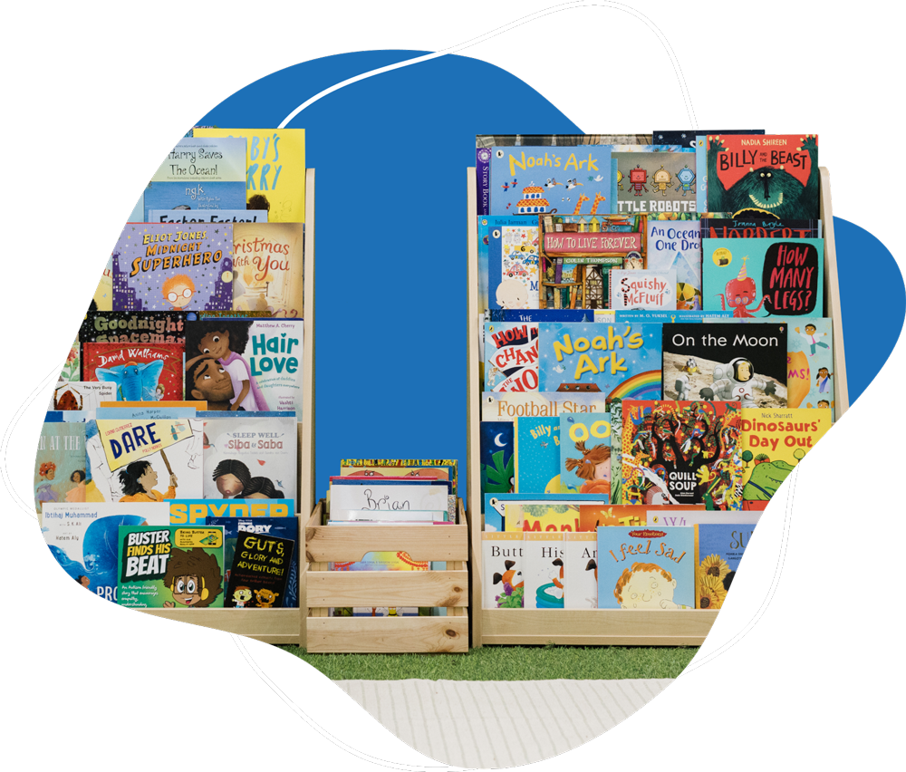 Two wooden racks filled with colorful children's books displayed standing on a green carpet with a blue abstract background.