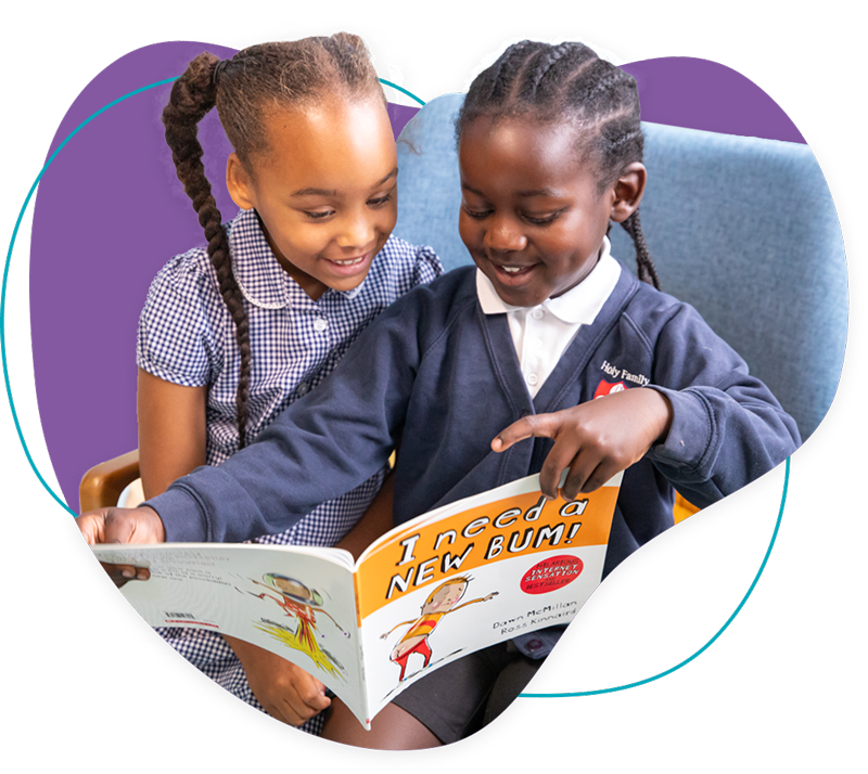 Two young girls sitting together, smiling and reading the book 'I Need a New Bum!'