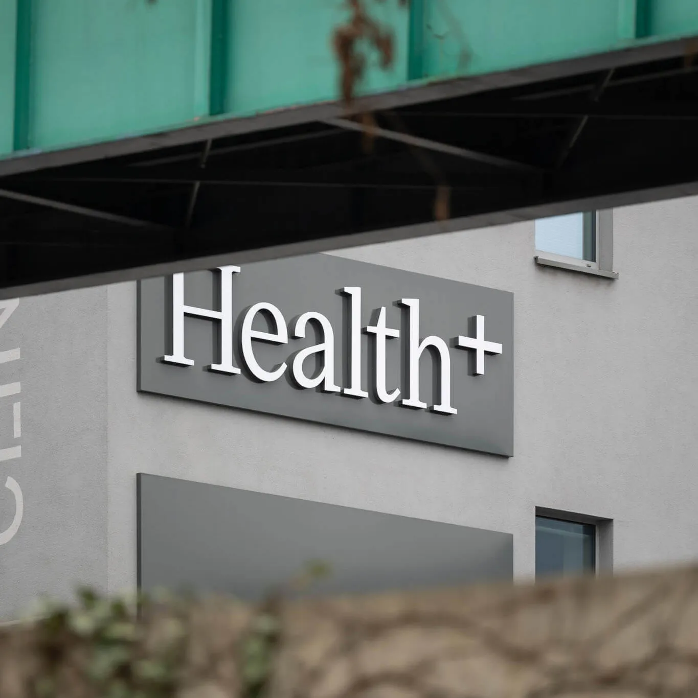 Označení kliniky Health+ na budově