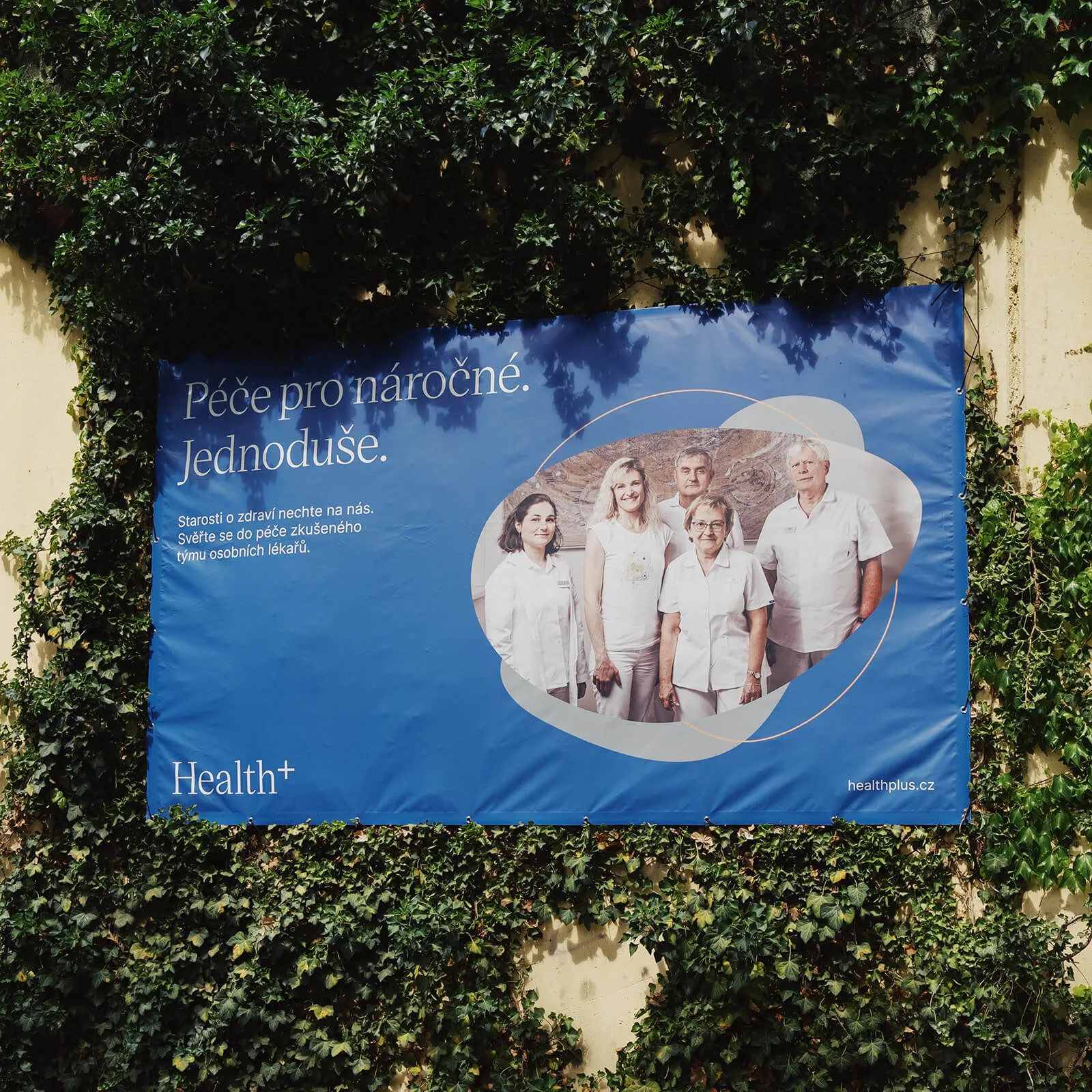 Banner s claimem a fotografií lékařů na stěně