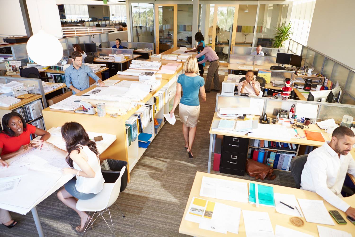 Busy modern open-plan agency office with staff collaborating
