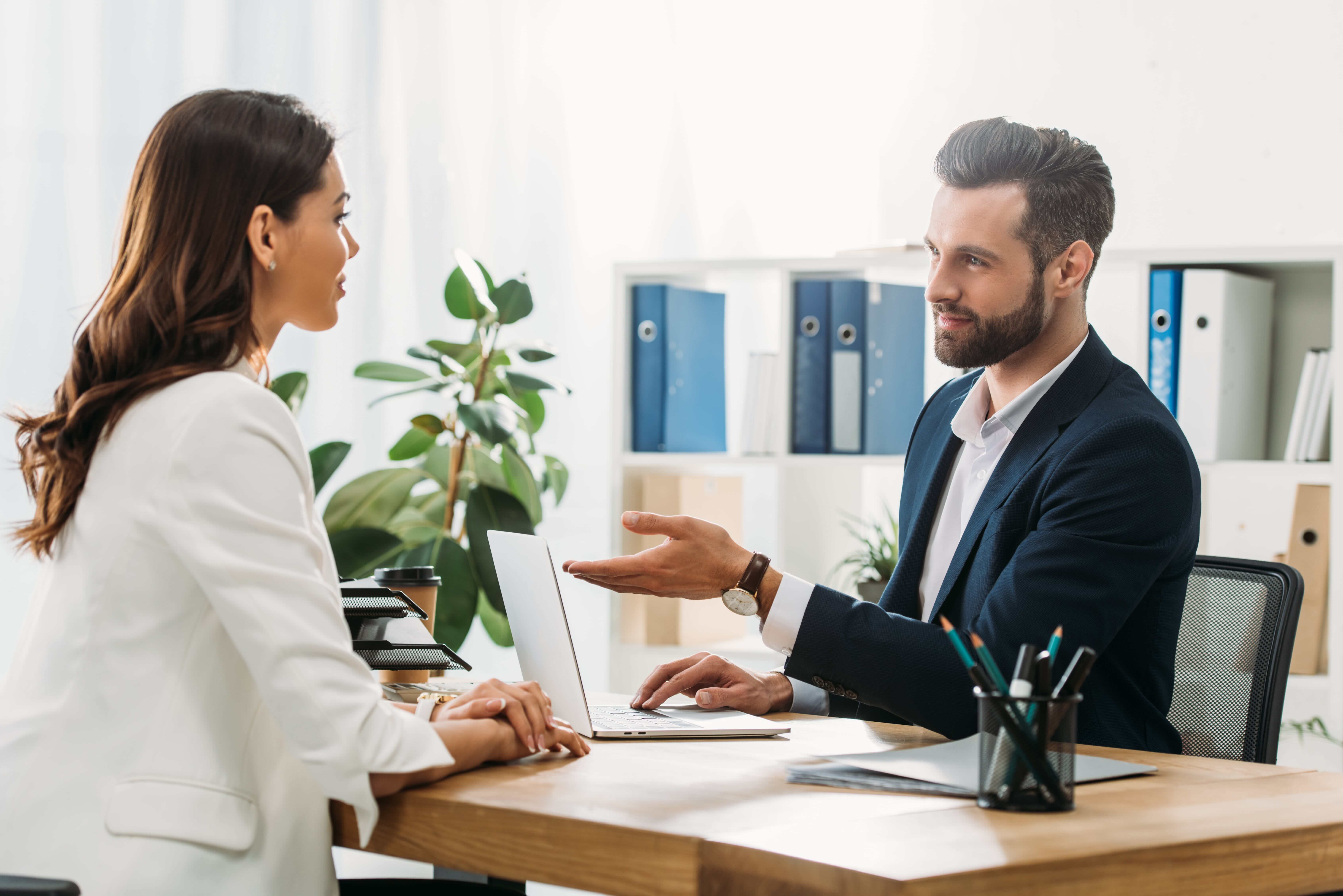 Handsome advisor in suit talking with employee