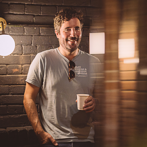 Person holding a coffee and chatting during a Proclaimers Ipswich church gathering at King Street Cinema