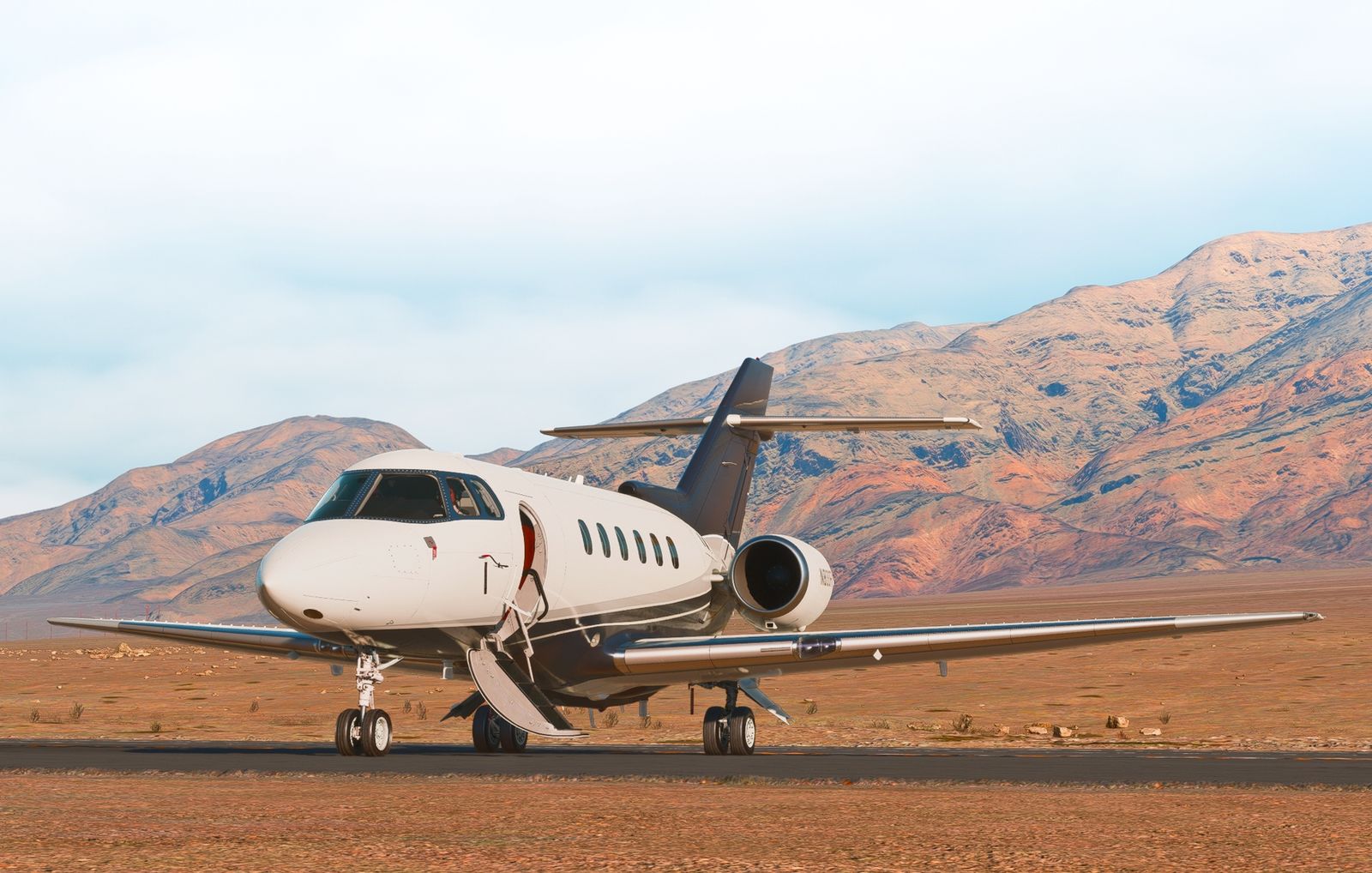 FlightFX Hawker 800XP parked with its entrance door open against a mountain backdrop