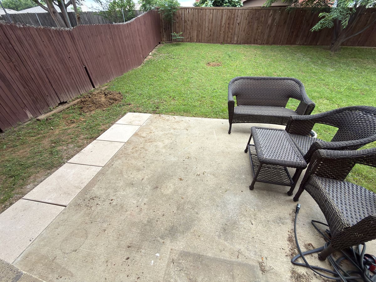 A back patio with pavers added to expand the concrete slab.
