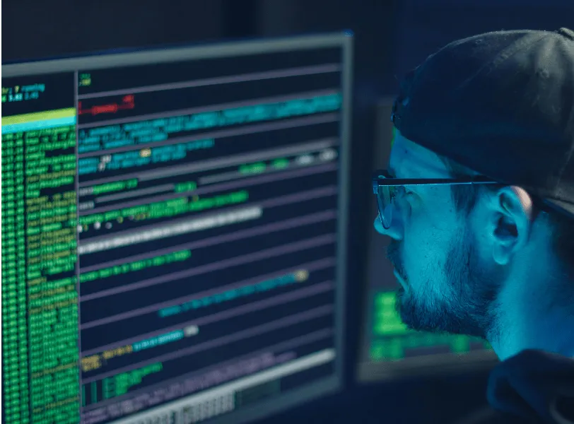 A developer sitting in front of a monitor writing code