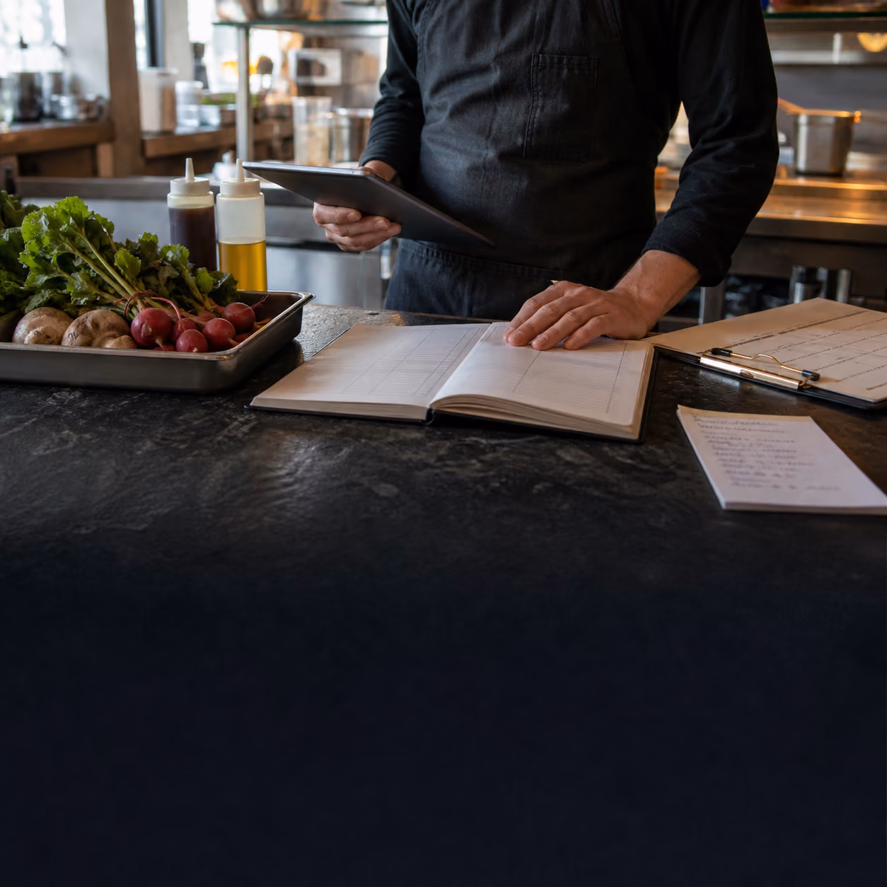 Restaurant operator reviewing forecast notes beside fresh produce
