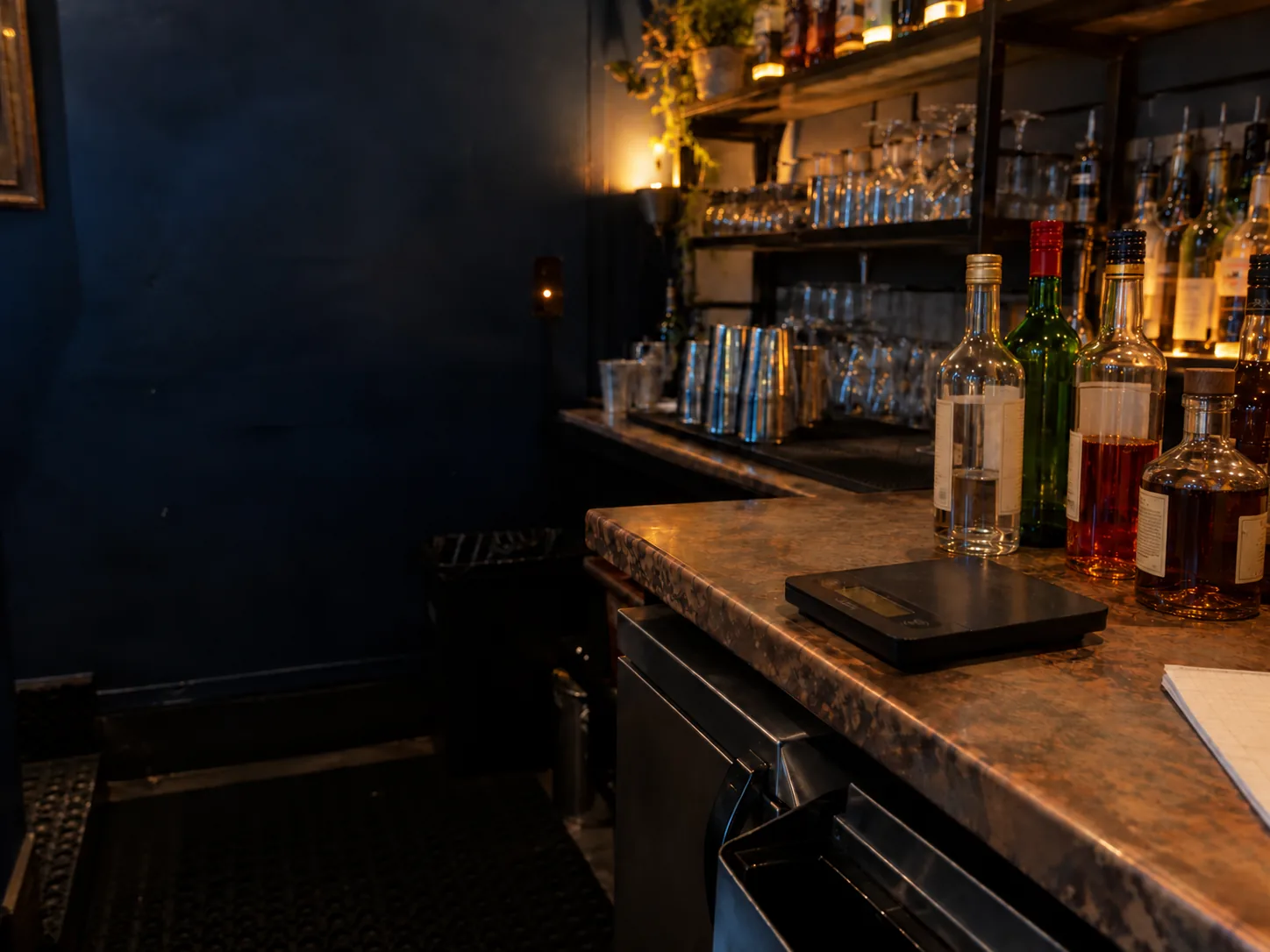 Illustrative bar inventory setup with mixed bottles and a digital scale