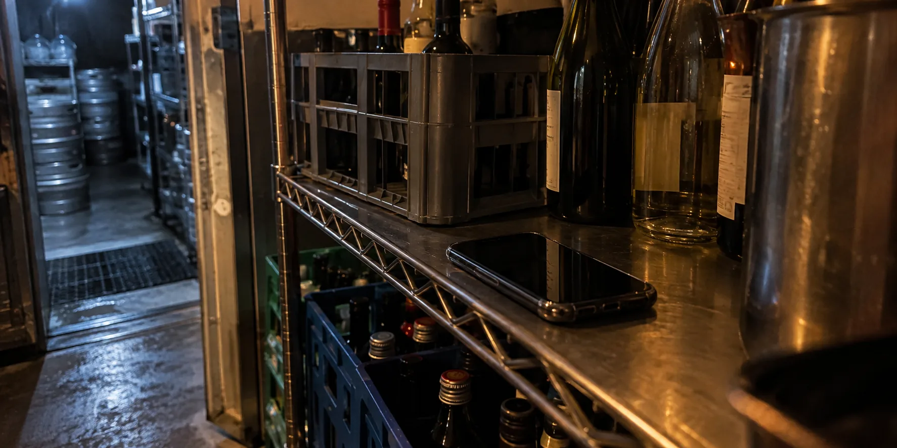 Phone beside bottles in a restaurant walk-in storage area