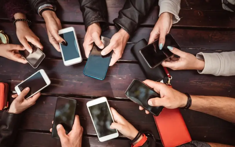 A group of people holding smartphones together, symbolizing participation in social media challenges and online engagement.
