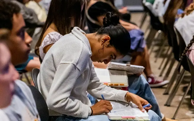 Student ambassador taking notes during training for an upcoming college career fair.